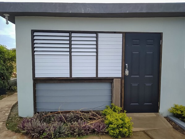 A modern building with a large window, a garage door, and a black door.