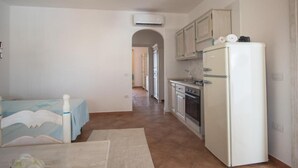 A compact kitchen with a refrigerator, oven, and sink.