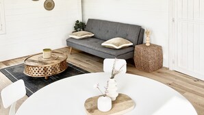 A modern living room with a grey sofa, round coffee table, and a large woven pendant light.