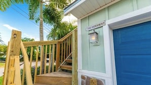A wooden staircase leading to a blue door labeled "The Hideaway." - Introducing our new Waterfront Hideaway Studio  (Palm City)