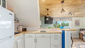 A modern kitchen with white cabinets, a wooden countertop, and a built-in oven. - Introducing our new Waterfront Hideaway Studio  (Palm City)