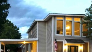 A two-story house with a covered driveway and an American flag. - Heroes Boulevard House with room for up to ten (Lawton)