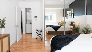A modern bedroom with a large bed, a mirror, and a walk-in closet. - ☞Kid Paradise☞5miles->Disneyland☞1 Parking☞W/D☞AC (Santa Ana)
