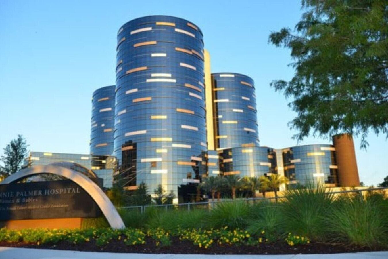 A modern hospital building with cylindrical structures and a sign for the Palmetto Health Women's & Babies Center.
