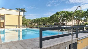 A swimming pool with a modern design, surrounded by a paved deck and a metal railing. - Lydie apt. exclusive holigarda (Desenzano del Garda)