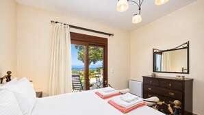 A hotel room with a bed, a dresser, a mirror, and a view of the outdoors.