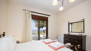 Un dormitorio con cama, cómoda, espejo y vistas al exterior.