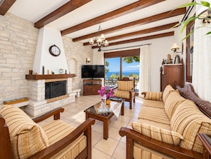 A living room with a fireplace, a television, and a sofa set.