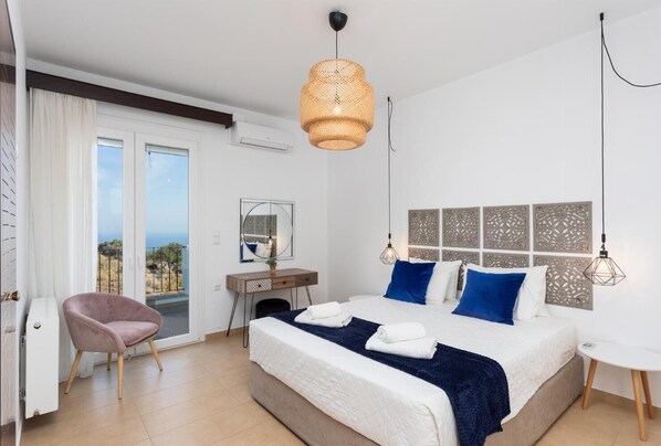 Une chambre moderne avec un grand lit, un bureau, une chaise et un balcon offrant une vue agréable.