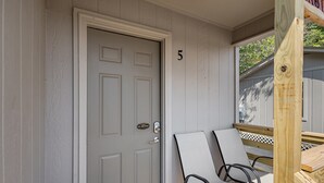 A door with a 'NO SMOKING' sign, a number '5' on the wall, and two chairs outside. - Cottage 5 - Smugglers Run (Ridgeland)