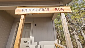 A wooden sign reading "SMUGGLER'S RUN" above a door marked with the number 5. - Cottage 5 - Smugglers Run (Ridgeland)