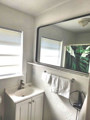 A bathroom with a white sink, a mirror, and a towel rack. - House with Patio, Caribbean Hot-tub & Tiki Bar. Pet friendly. No cleaning charge (Punta Gorda)