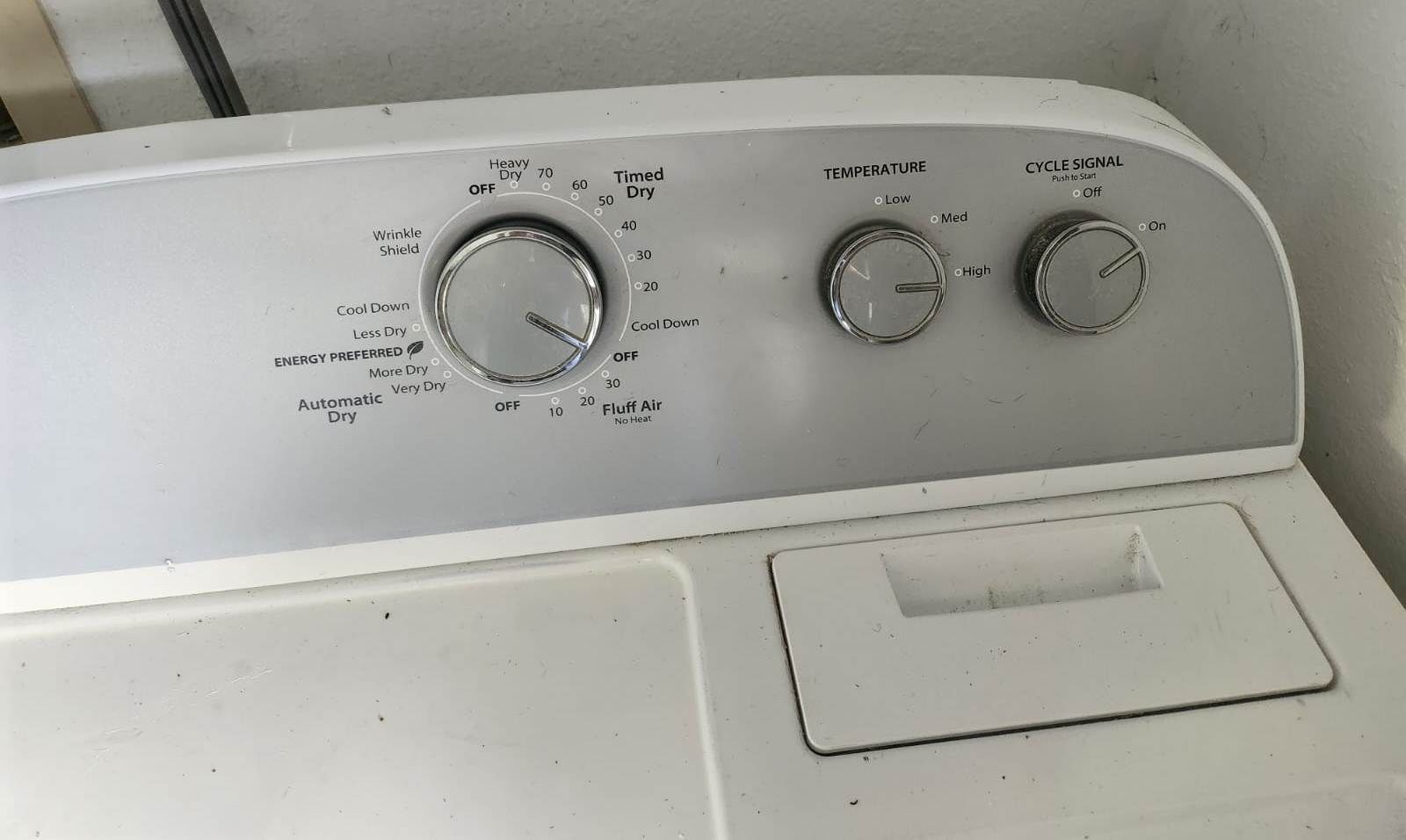 A front view of a washing machine with control knobs for temperature and cycle signal.
