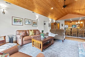 A spacious living area with a leather sofa, a wooden coffee table, and a dining area with wooden chairs and a table. - KBM Resorts | Town Pointe | 1 level with views of mountains, Walk to Main and Town Lift, Elevator access, Parking, A/C! TPC-301c (Park City)