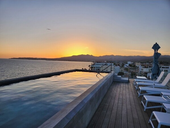 Enjoy breathtaking views of the water and distant mountains from this serene rooftop terrace.