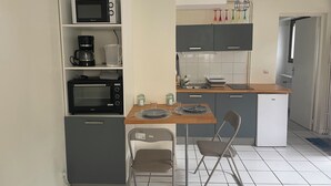 A compact kitchen with a microwave, coffee maker, toaster, and a small refrigerator. - Le Vert Galant (Morsang-sur-Orge)