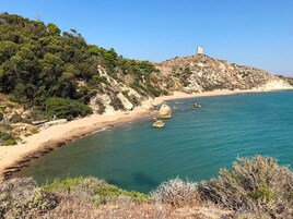 Una playa cerca, arena blanca, sombrillas, toallas de playa