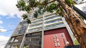 En modern byggnad med en röd fasad och en skylt med texten ”ESCA DA”.