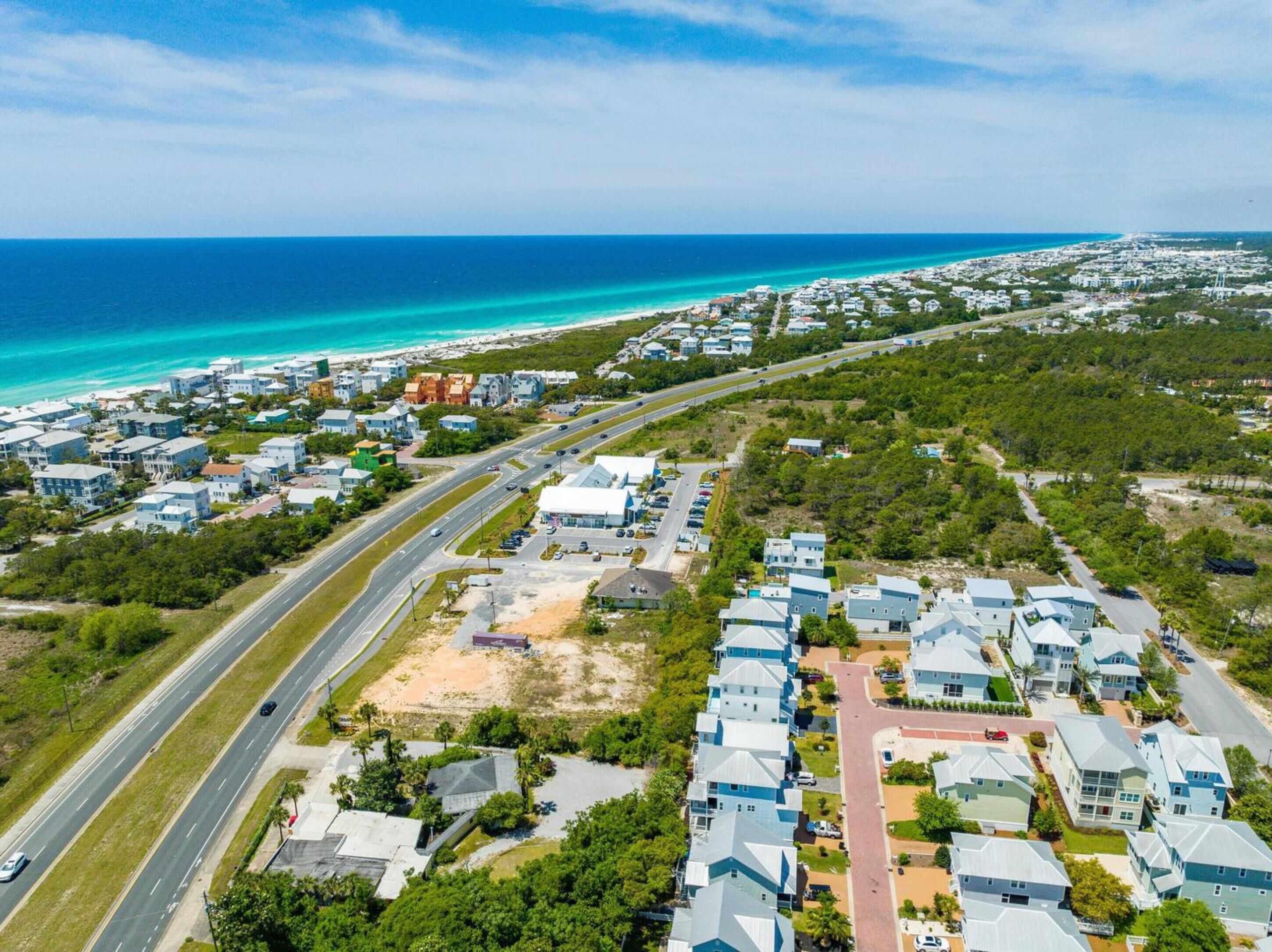 Vista aérea de una zona residencial costera con casas, carreteras y una playa.