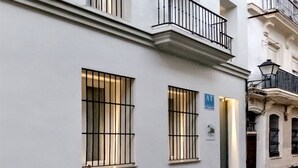 Een meerlaags gebouw met balkons, een deur met een ‘A’ bordje en tralies voor de ramen.