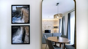 Un comedor moderno con una mesa redonda, sillas grises y una pared de piedra al fondo.