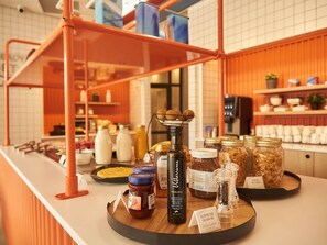 A kitchen counter with various food items and condiments, including jars of olive oil and a bottle of honey.