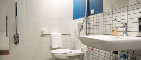 Un baño moderno con inodoro, lavamanos y ducha.