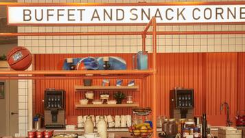 A buffet and snack corner with a sign, shelves with food items, and kitchen appliances.