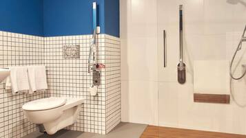 A bathroom with a toilet, a shower, and a sink.