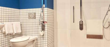 A bathroom with a toilet, a shower, and a sink.