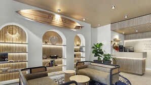 Vestíbulo de hotel con asientos, mostrador de recepción y paneles de madera.
