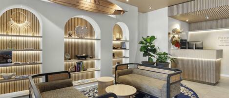 A hotel lobby with seating, a reception desk, and wooden paneling.
