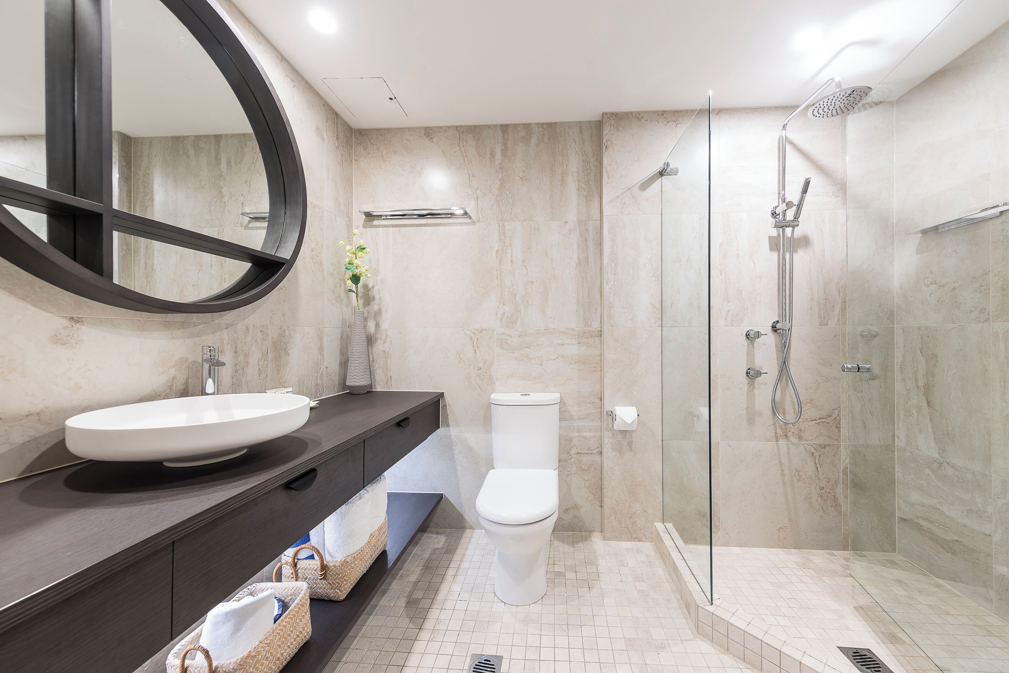 Uma casa de banho moderna com uma grande lavatório oval, uma sanita e cabine de duche com vidro.