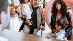 A family interacting in a modern indoor space with large windows and indoor plants. - Pullman Lyon  (Lyon)