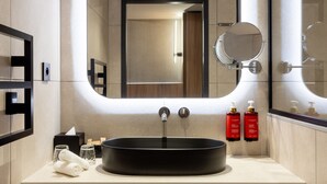 A modern bathroom with a large mirror, a round sink, and neatly folded towels. - Pullman Lyon  (Lyon)