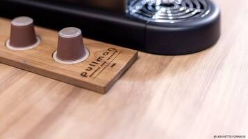 Une machine à expresso de type « Pullman », au design noir et métallique, posée sur une surface en bois.