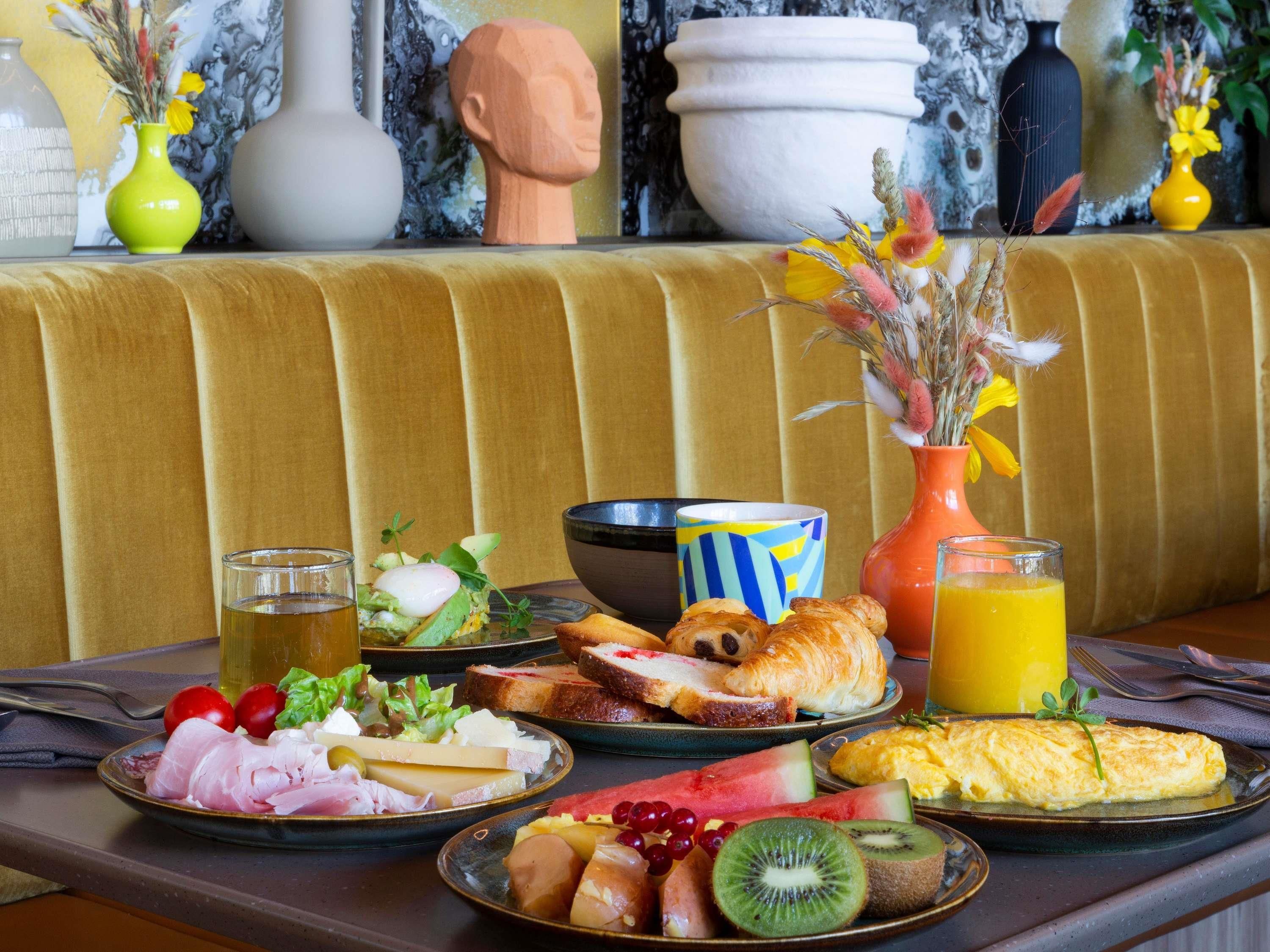 Un desayuno con platos de comida, un florero y un bol.