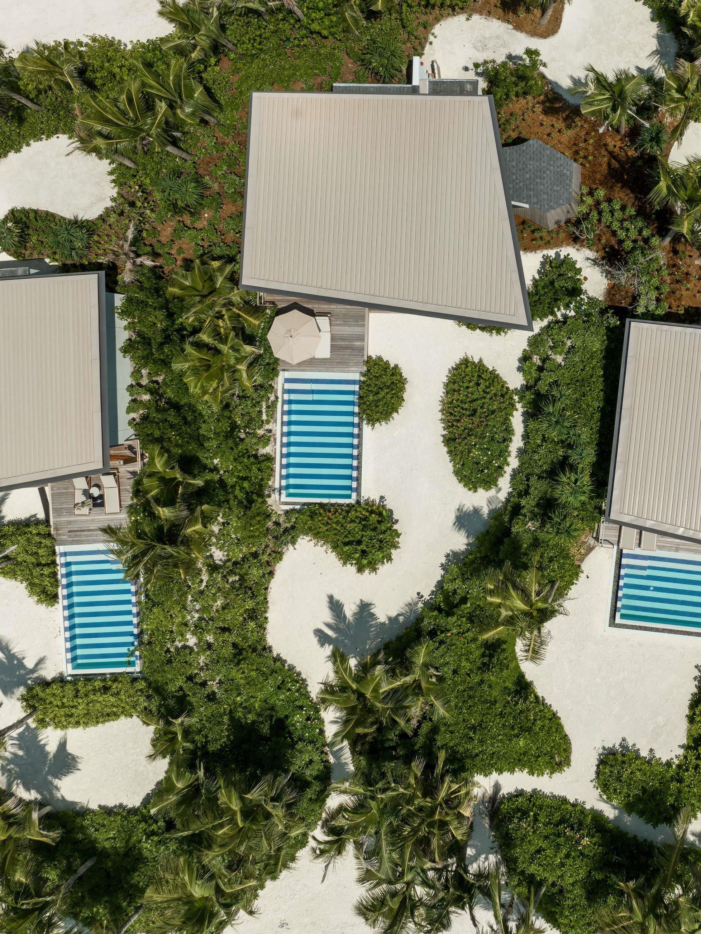Oversigtsbillede af et resort med flere swimmingpools, palmer og resortbygninger.