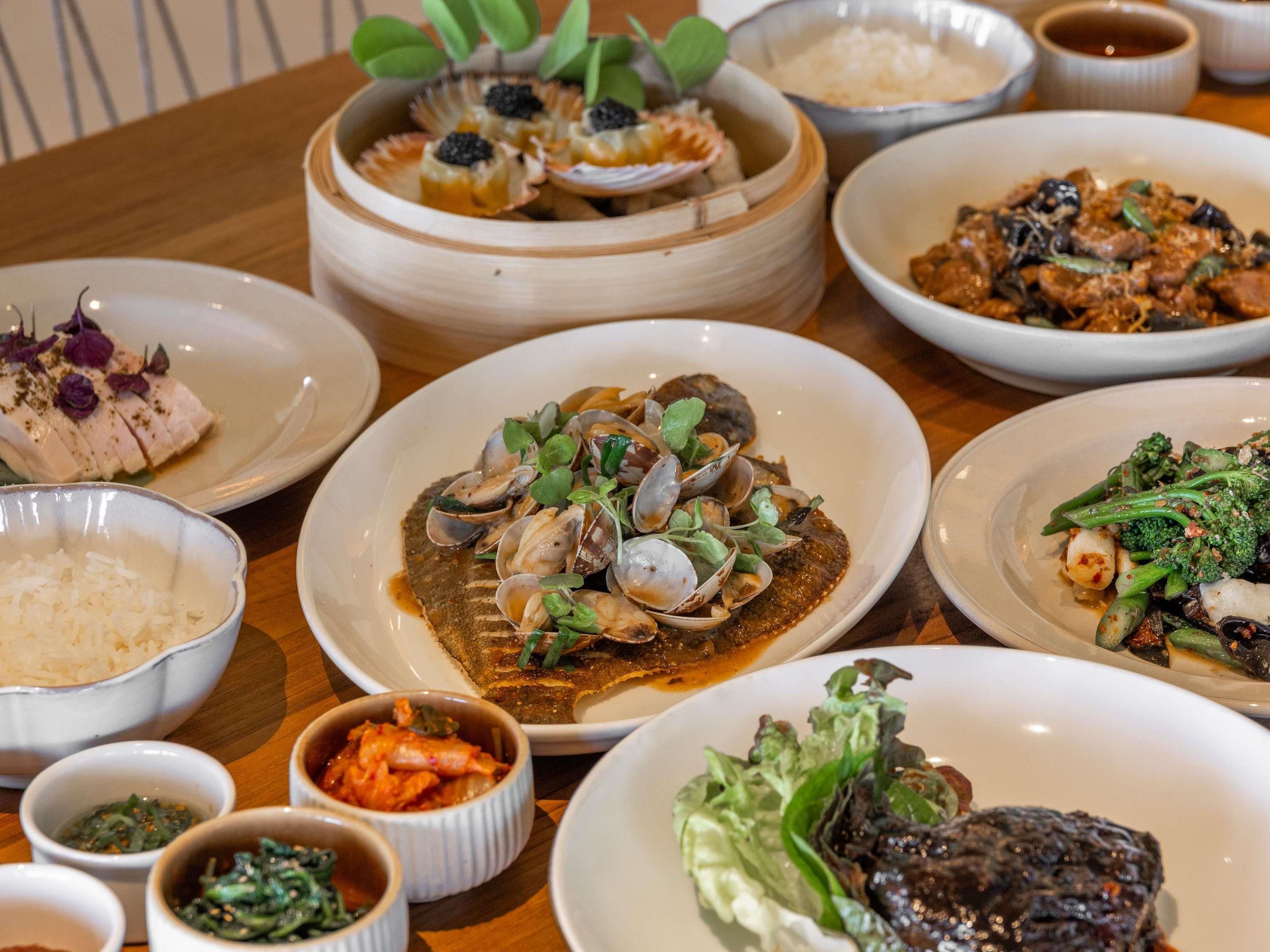 A variety of dishes on a table, including seafood, vegetables, and rice.