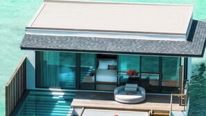A modern overwater villa with a glass-enclosed bedroom, a private pool, and a wooden deck. - SO/ Maldives (Emboodhoo)