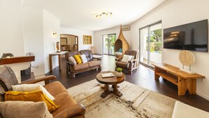 A spacious living room with a fireplace, leather sofas, a coffee table, and a large TV. - Villa with private pool in Vilamoura (Vilamoura)