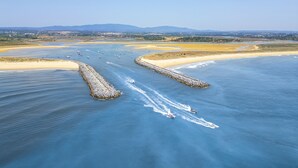An aerial view of a coastal area with a clear sky, a sandy beach, and a waterway with boats. - Villa with private pool in Vilamoura (Vilamoura)