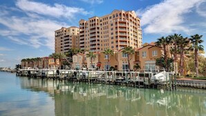Ein Hotel am Wasser mit mehreren Balkonen, einer Marina und Palmen.