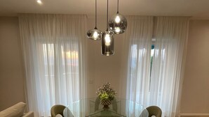 A modern dining area with a glass table, four chairs, and a central vase. - MAISON LARA - Luxury home in the center of Sorrento (Sorrento)