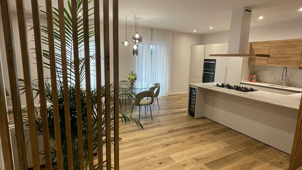 A modern kitchen with wooden flooring, a central island, and pendant lighting. - MAISON LARA - Luxury home in the center of Sorrento (Sorrento)