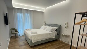 A modern bedroom with a bed, a chair, a bedside table, and a wardrobe. - MAISON LARA - Luxury home in the center of Sorrento (Sorrento)
