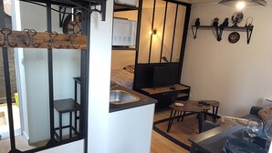 A compact living space with a kitchenette, a dining area, and a seating area. - Studio cosy Saint-Étienne centre (Saint-Ã‰tienne)