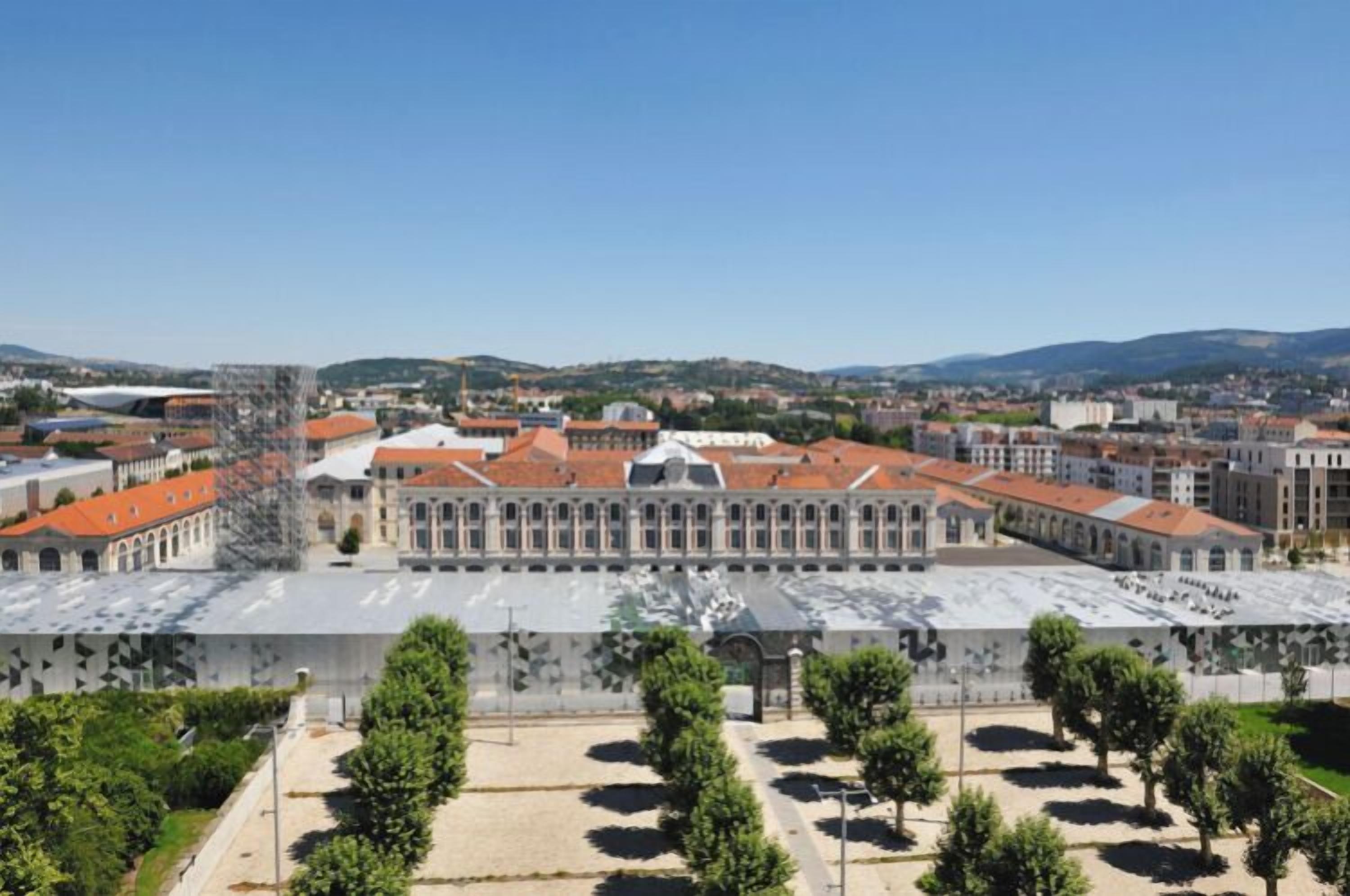 Un edificio grande e histórico con fachada simétrica, un patio central y un paisaje urbano circundante.