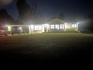 Une maison d’habitation avec un garage, une allée et une pelouse.