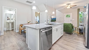 A modern kitchen with a central island, pendant lighting, and a ceiling fan. - Fall Getaway in Asheville w/Hot Tub & Fire Pit! (Asheville)